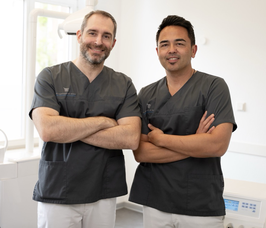 Dr. Würdinger und Dr. Reiser lächeln in der Praxis