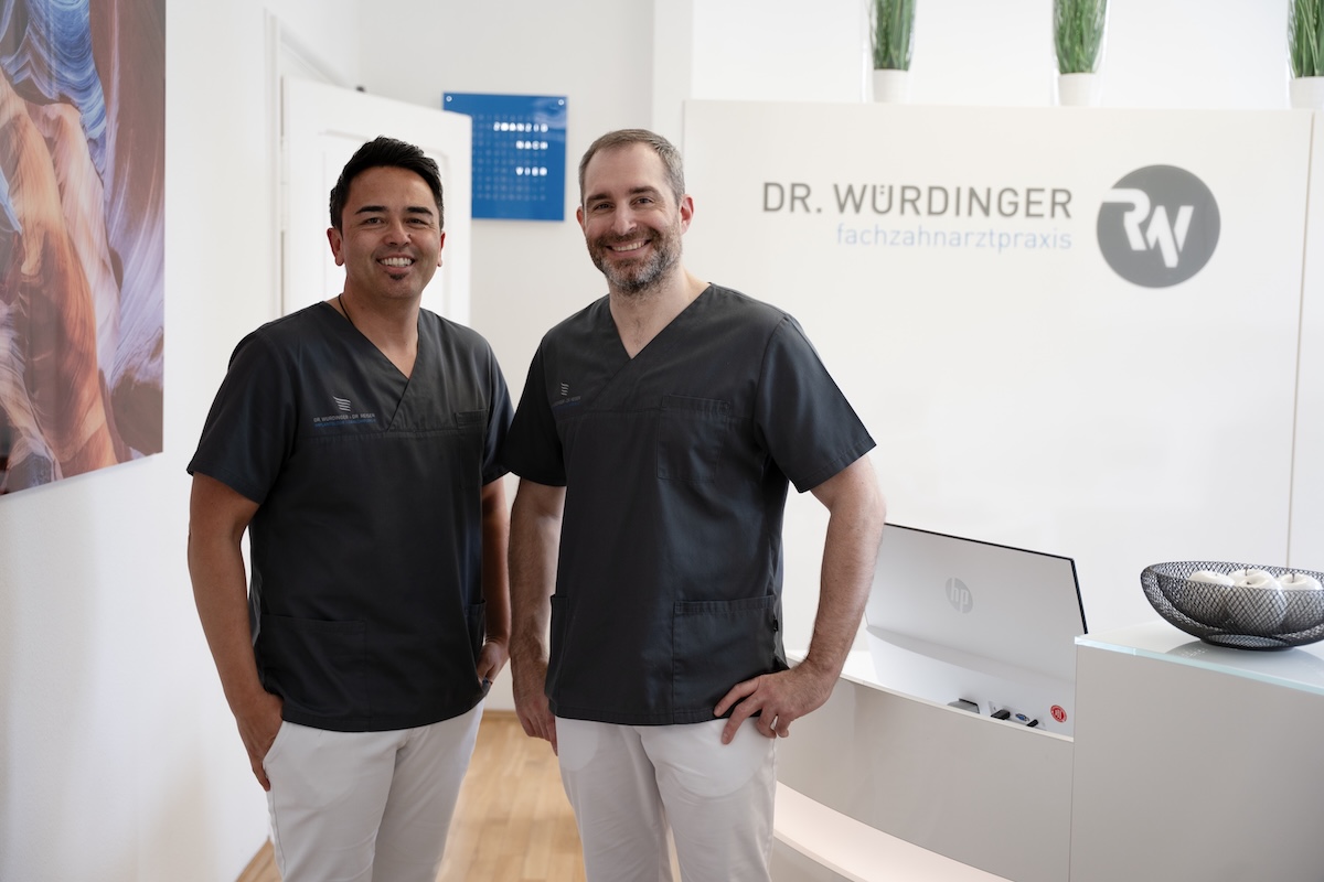 Dr. Würdinger und Dr. Reiser lächeln in der Praxis